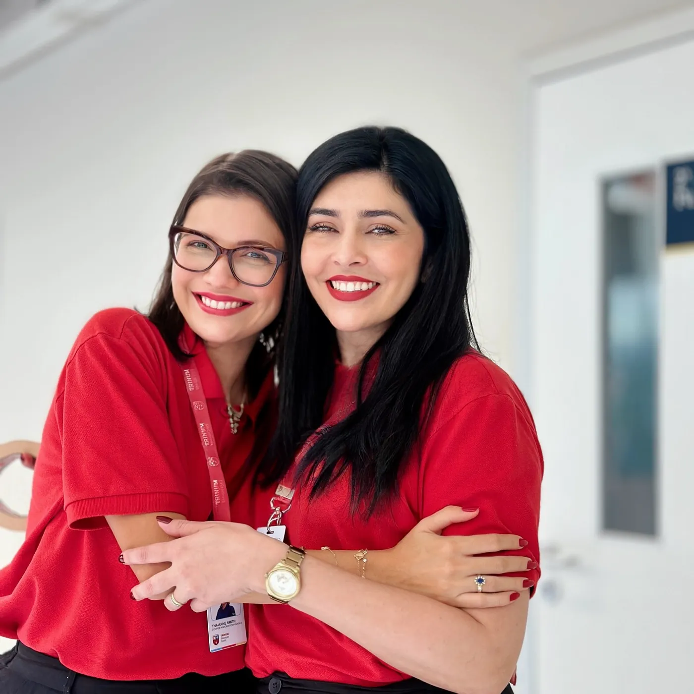Duas educadoras da Trinum abraçadas e sorrindo