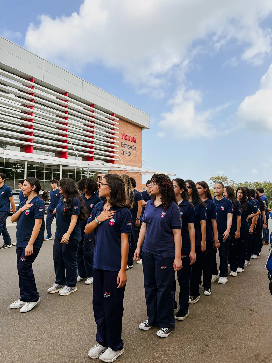 Alunos reunidos diante da fachada da escola